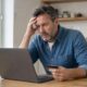 Besorgter Mann am Laptop nach Online-Kauf bei einem Fake-Shop