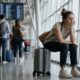 Wartende Reisende mit Koffern in einem Flughafenterminal