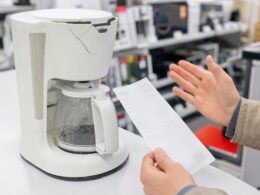 Defektes Kuechengeraet mit Kassenbon auf einer Ladentheke