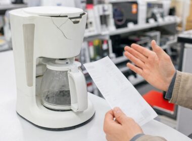 Defektes Kuechengeraet mit Kassenbon auf einer Ladentheke